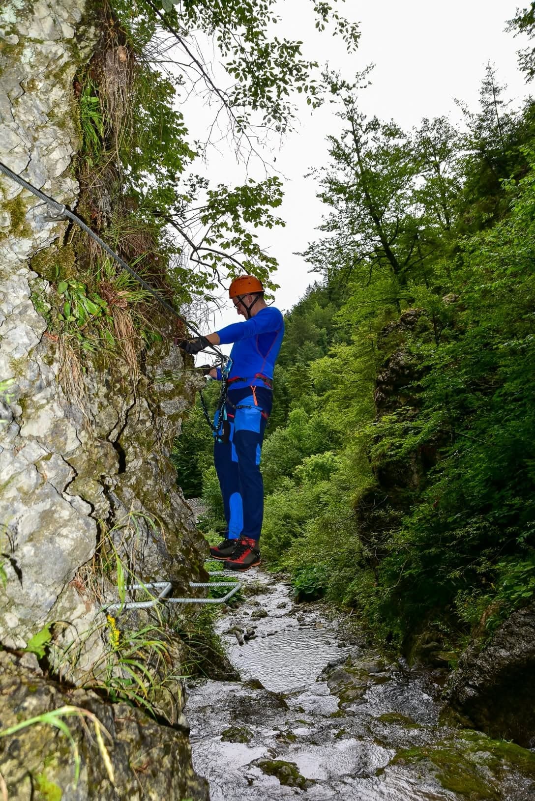 Plezalec s čelado na skalni steni